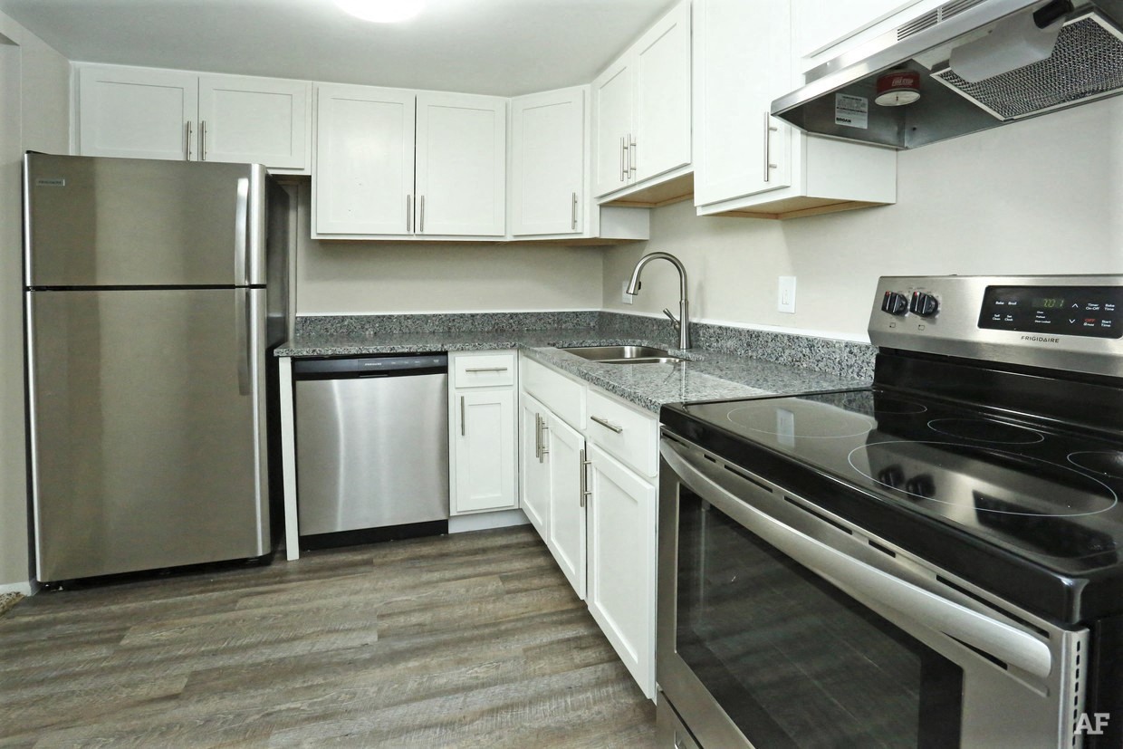 Kitchen with granite counters, stainless appliances, and white cabinets